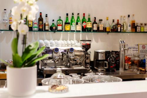 a kitchen counter with a coffee machine and bottles of alcohol at Albergo La Rocca in Brisighella