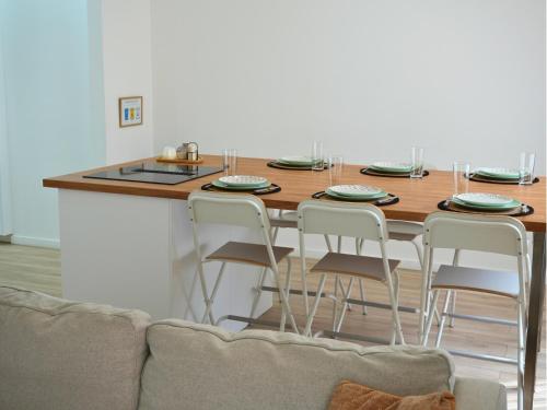 a kitchen with a table with four chairs around it at Duplex familiale 3 chambres, 3 salles de bains & jardin à Bruxelles by CYGO Gestion in Brussels