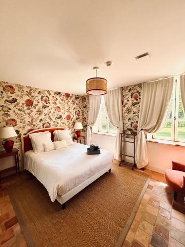 a bedroom with a large bed with floral wallpaper at Manoir de Daubeuf in Daubeuf-Serville