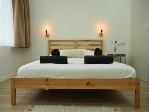 a bedroom with a bed with two pillows on it at Duplex familiale 3 chambres, 3 salles de bains & jardin à Bruxelles by CYGO Gestion in Brussels