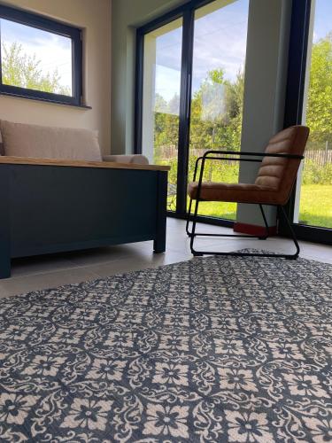 a bedroom with a bed and a chair and windows at La Jura in Podlesice