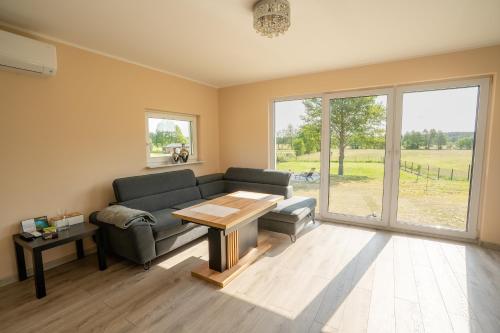 a living room with a couch and a table at Domek wakacyjny Średnia Huta in Warlubie