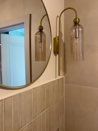 a bathroom with two lights and a mirror at La Jura in Podlesice