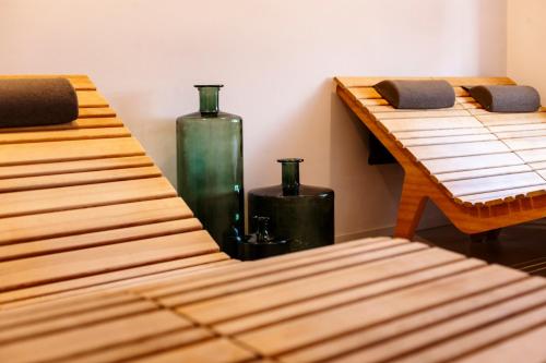 a row of wooden beds in a room with vases at Albergo La Rocca in Brisighella