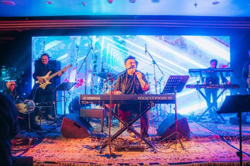 a group of people playing music on a stage at The Khyber Himalayan Resort & Spa in Gulmarg