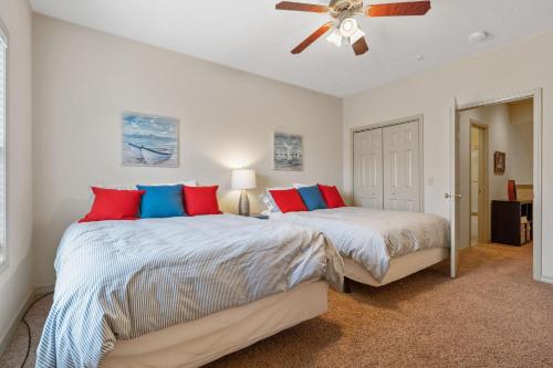 two beds in a bedroom with a ceiling fan at The Gathering Place - Minutes to 61-Acre Theme Park in Branson West