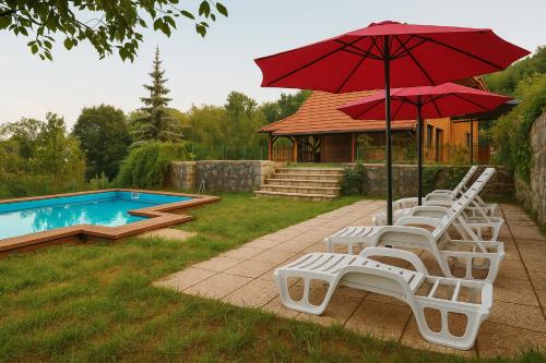 a group of chairs and an umbrella next to a pool at Villa Felix with spectacular pool in green oasis in Opatija