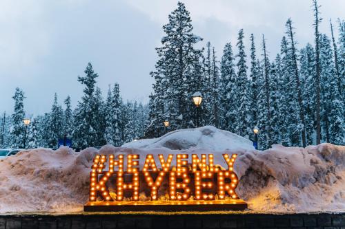 a sign that says merry christmas in front of snow at The Khyber Himalayan Resort & Spa in Gulmarg