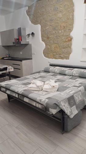 a large bed in a room with a wall at My Mini Maison in Castel dʼAiano