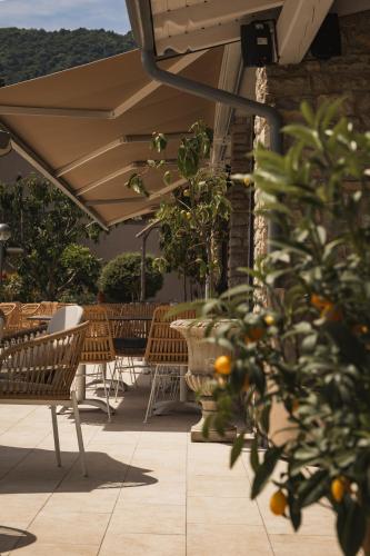 an outdoor patio with tables and chairs and an umbrella at Hotel MioMio in Tignale