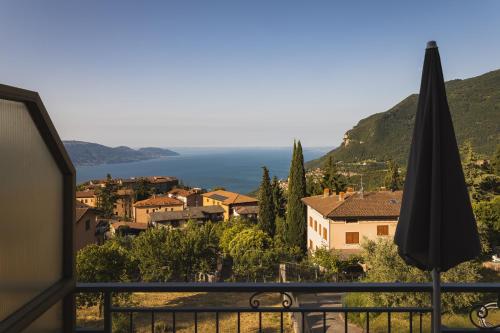 a view of a town from a balcony with an umbrella at Hotel MioMio in Tignale