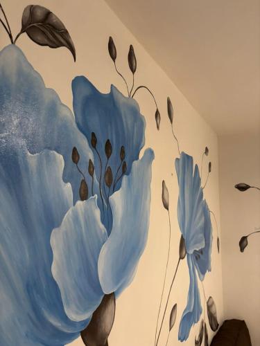 a mural of blue flowers on a wall at La Plata - ZORZAL - Alquiler Temporal in La Plata