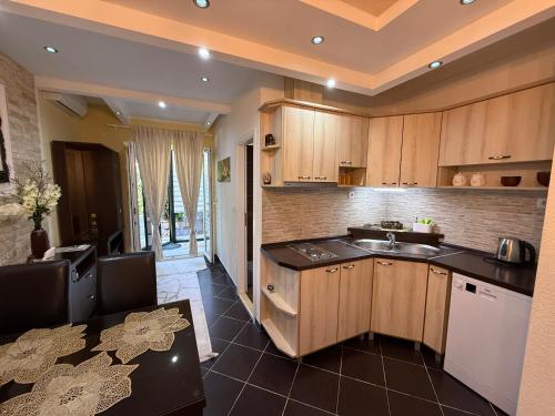 a kitchen with wooden cabinets and a sink at Grand Apartments Scepanovic in Tivat