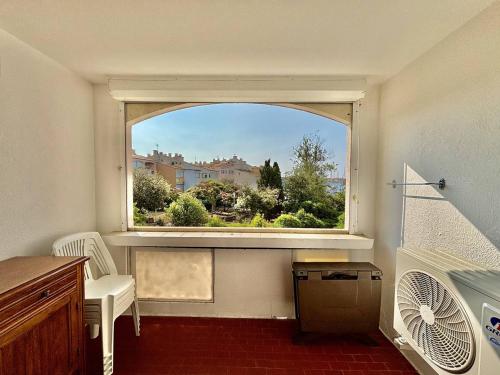 une pièce vide avec une grande fenêtre avec un radiateur dans l'établissement Port, jardins, clim, calme, centre Cap d'Agde - FR-1-723-43, au Cap d'Agde