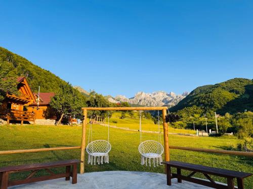 a porch with two benches and a swing at Bujtina Pepushaj Lepushe in Lëpushë