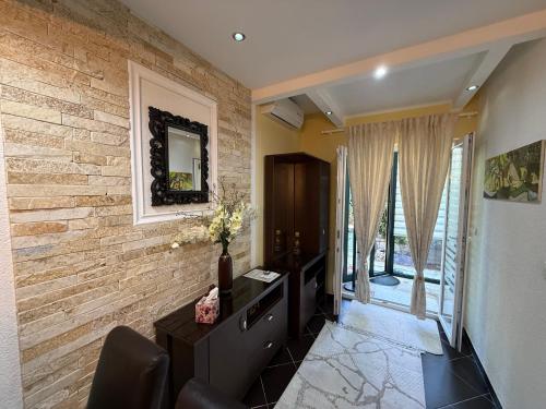 a living room with a brick wall and a desk at Grand Apartments Scepanovic in Tivat