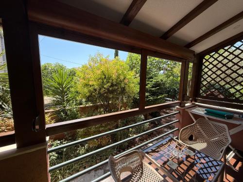a balcony with two chairs and a view of trees at Grand Apartments Scepanovic in Tivat