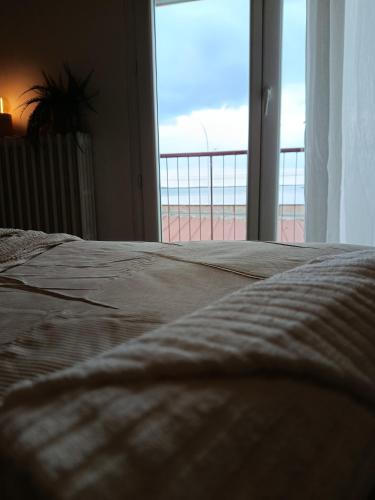 a bedroom with a bed with a view of the ocean at Chti Moutchico in Lacanau