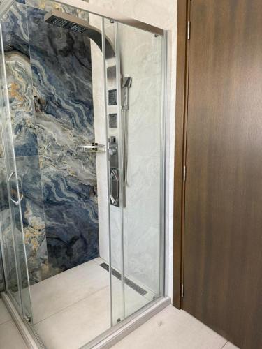 a shower with a glass door in a bathroom at ForS Konak Apartments in Belgrade