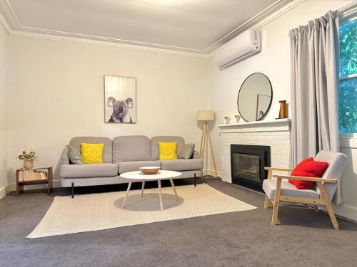 a living room with a couch and a table at Bendigo Bliss - Cheerful & Spacious Home in Bendigo in Kangaroo Flat