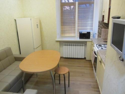 a small kitchen with a table and a refrigerator at Apartment Lenina 9/11 in Ufa