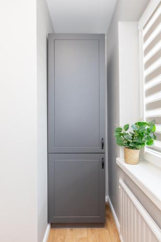 a gray door in a room with a plant at Miniukas in Kaunas