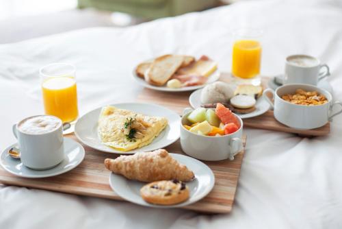 a tray of breakfast foods on a table with orange juice at Hotel Riu Palace La Mola in Playa Migjorn