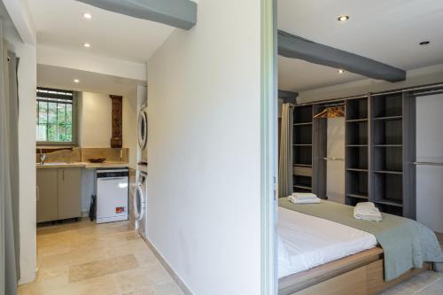 a bedroom with a bed and a kitchen at Apt La Fontaine in Tourrettes-sur-Loup