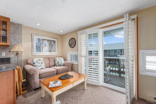 a living room with a couch and a table at Oceanside Condos in Dennis Port