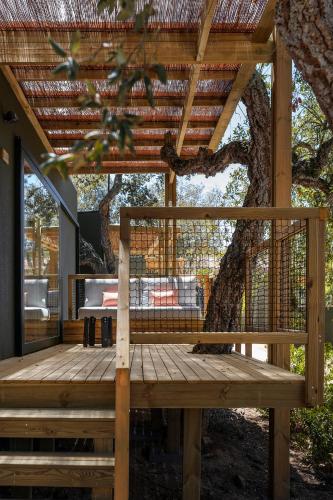 a wooden deck in front of a tree at wecamp Santa Cristina in Santa Cristina d'Aro