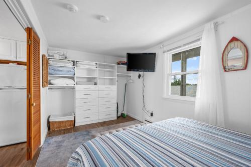a bedroom with a bed and a tv in it at Oceanside Condos in Dennis Port