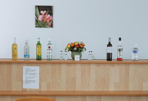 a bar with bottles of wine and flowers on it at Aeriko Hotel Apartments in Arvanitochori