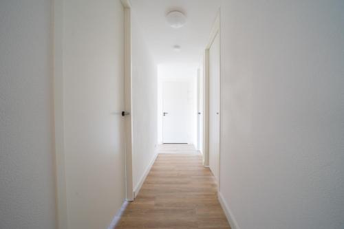 an empty corridor with white walls and wooden floors at EuroParcs De Kraaijenbergse Plassen in Groot-Linden