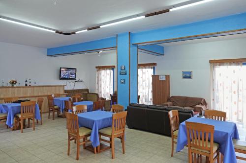 a dining room with blue tables and wooden chairs at Aeriko Hotel Apartments in Arvanitochori