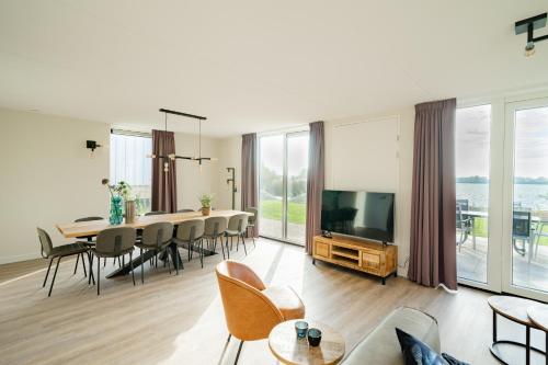 a living room with a dining table and a television at EuroParcs De Kraaijenbergse Plassen in Groot-Linden