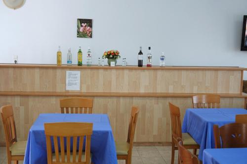 a dining room with tables and chairs and a bar at Aeriko Hotel Apartments in Arvanitochori