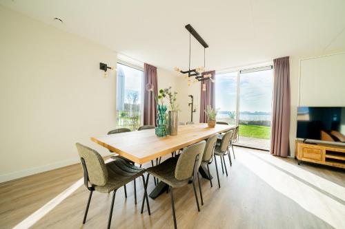 a dining room with a wooden table and chairs at EuroParcs De Kraaijenbergse Plassen in Groot-Linden