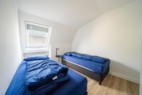 a bedroom with two beds and a window at EuroParcs De Kraaijenbergse Plassen in Groot-Linden