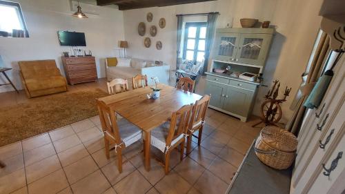 a kitchen and dining room with a wooden table and chairs at Kelepelő Porta in Poroszló