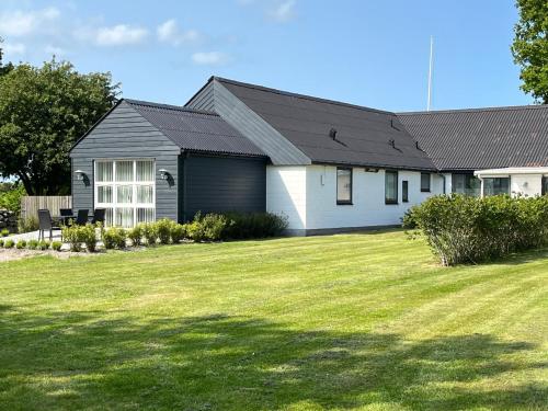a house with a grass yard in front of it at Pilegården Ferieboliger in Læsø