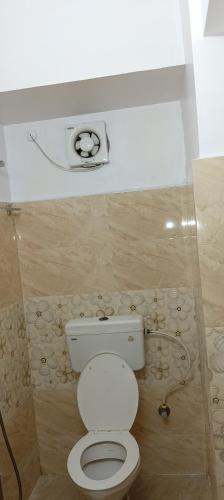 a bathroom with a toilet and a camera on the wall at Sacred Stay in Guwahati