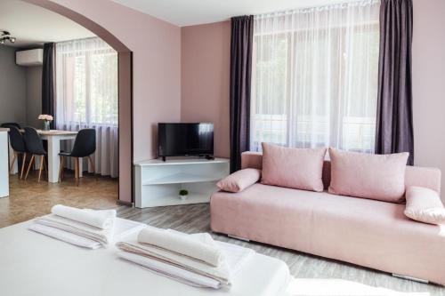 a living room with a pink couch and a tv at Hrisi&Kris in Sapareva Banya