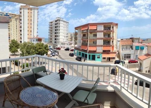 a table and chairs on a balcony with a view of a city at Apartamento Bellreguard Playa in Playa de Miramar