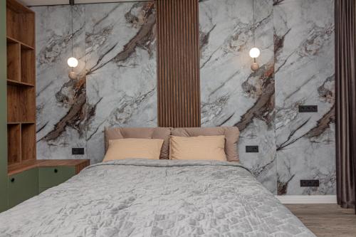 a bedroom with a bed and a marble wall at Exclusive Apartment 2 in Chişinău