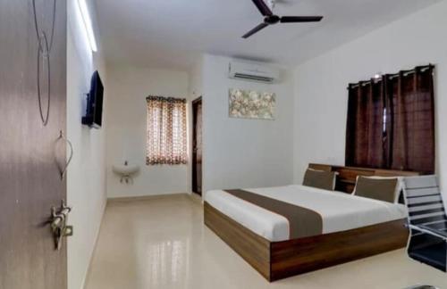 a bedroom with a bed with a ceiling fan at Serene Residency 1BHK SkylineView by Homeyhuts in Lingampalli