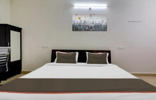 a large white bed in a room with at Serene Residency 1BHK SkylineView by Homeyhuts in Lingampalli