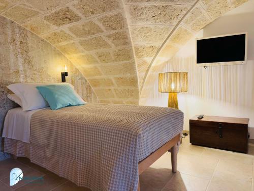 a bedroom with a bed with a stone wall at Annina guest house soggiorno vista mare in Savelletri di Fasano
