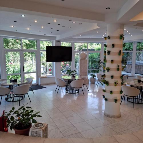 een lobby met tafels en stoelen en een flatscreen-tv bij Pensiunea Warthe Bed & Breakfast in Braşov