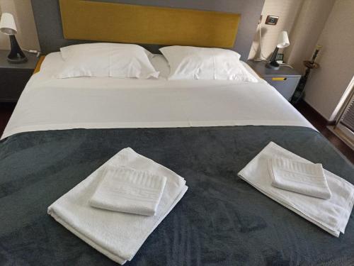 un letto con due asciugamani bianchi seduti sopra di The cozy flat a Tirana