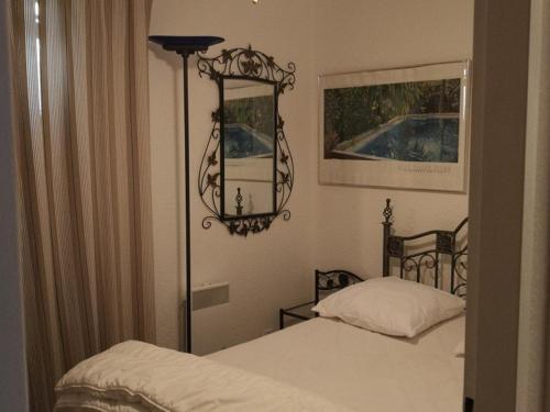 - une chambre avec 2 lits jumeaux et un miroir dans l'établissement Appartement T2 confortable pour 4 pers, RDC, terrasse, parc arboré, piscine, WIFI, parking gratuit - FR-1-195-4, au Barcarès